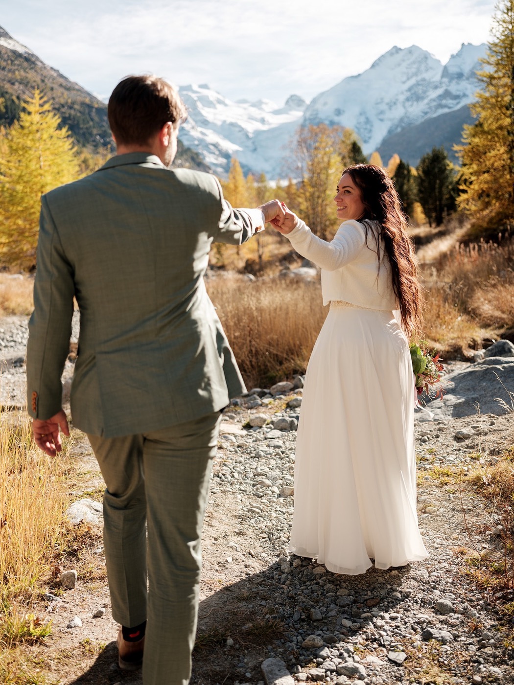 Braut führt Bräutigam an der Hand, Aktion-Pose fürs Hochzeitsshooting, Hochzeitsfotograf Graubünden