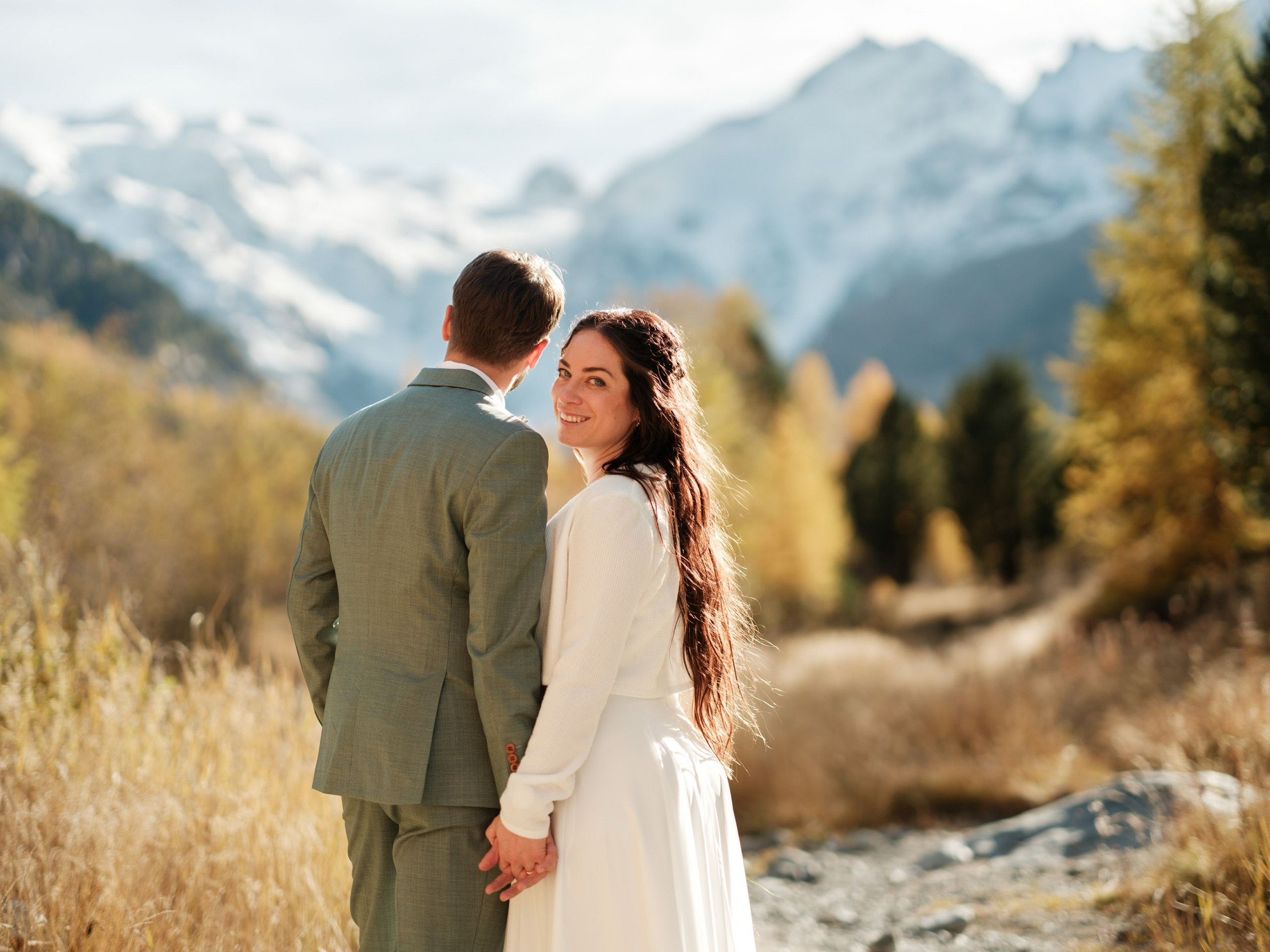 Brautpaar hält Hände in den Bergen des Engadins — Tipps für natürliche Posen beim Paarshooting, Hochzeitsfotograf Graubünden